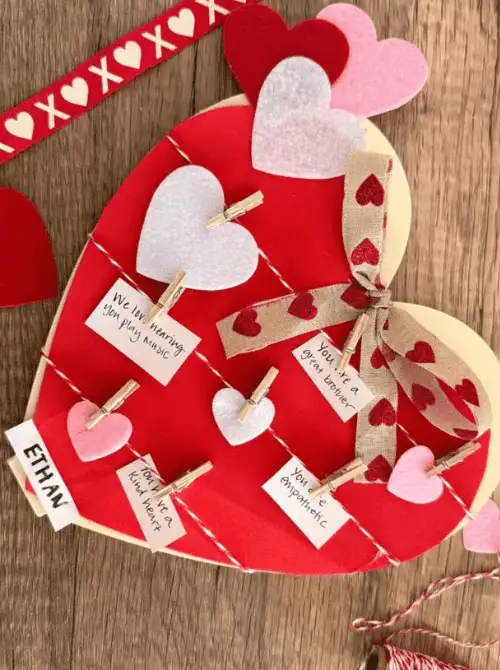 Valentine love notes board with heart cutouts and mini clothespins, a Valentine’s DIY craft made on a Dollar Tree budget.