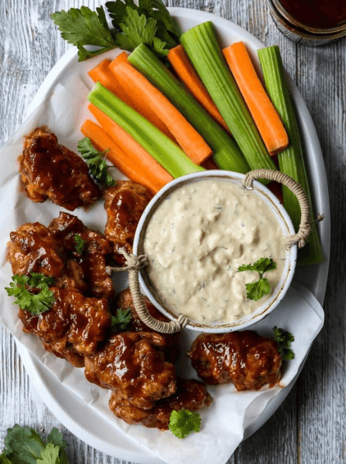 Vegan buffalo wings served with ranch-style dip and veggie sticks, a cheap tailgate food and simple Super Bowl appetizer for a crowd.