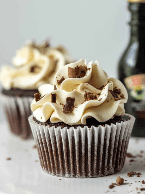 Close-up of a rich chocolate cupcake topped with swirled Baileys buttercream and chocolate shavings, styled as part of St. Patrick’s Day Dessert Ideas for an adults-only dessert table.