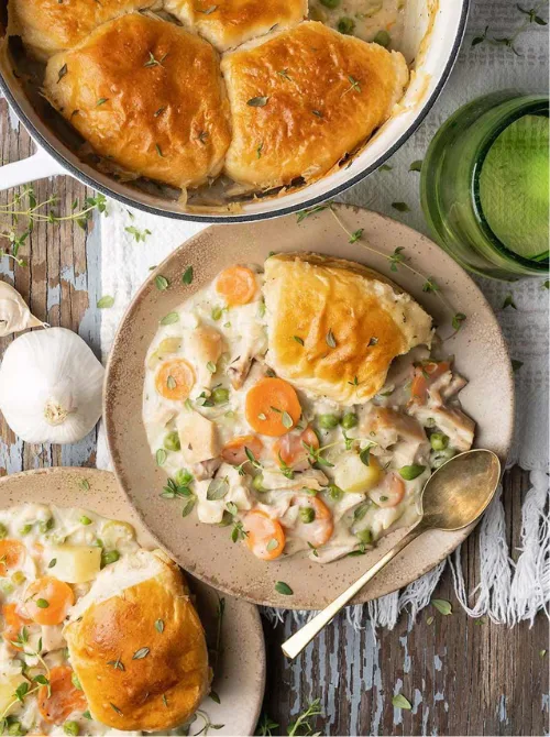Plated chicken pot pie casserole with flaky biscuit topping, carrots, peas, and creamy sauce, a classic example of chicken casseroles perfect for easy weeknight dinners.