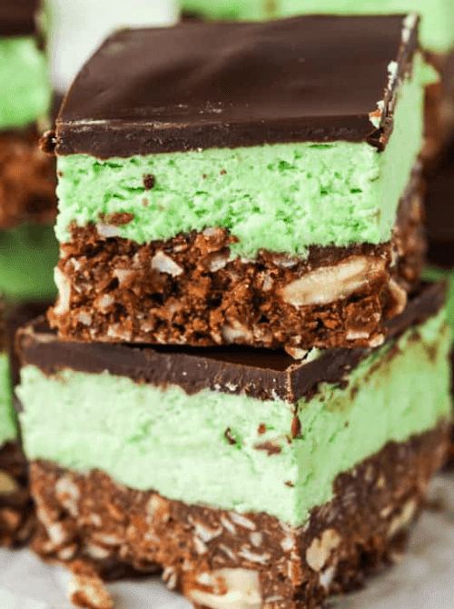 Stacked chocolate mint Nanaimo bars with green filling and chocolate topping, a make-ahead dessert for St. Patrick’s Day that works well as desserts on a budget.