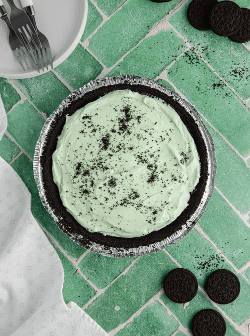 Mint Oreo no-bake pie in a chocolate cookie crust, festive St. Patrick’s Day dessert on a budget.