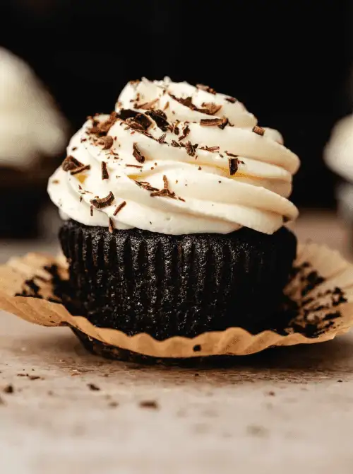 Moist Guinness chocolate cupcake with thick Irish cream frosting and chocolate shavings, featured in St. Patrick’s Day Dessert Ideas for a rich, grown-up party spread.
