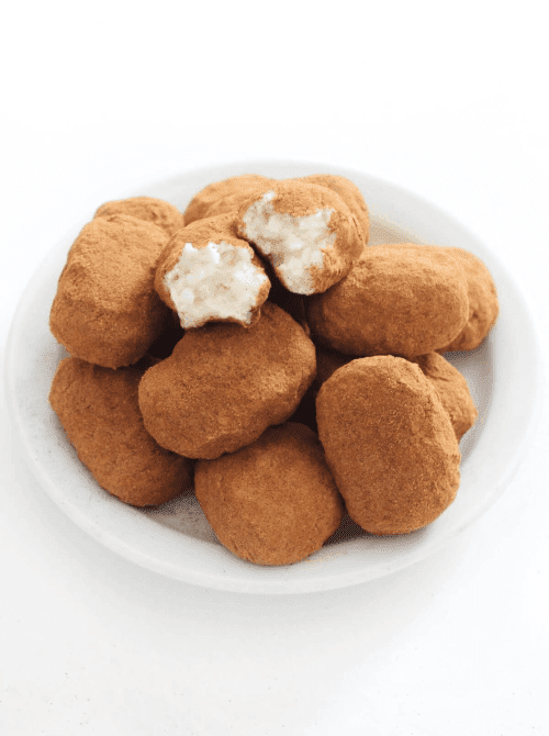 Irish potato candy rolled in cinnamon on a white plate, traditional no-bake St. Patrick’s Day dessert on a budget.