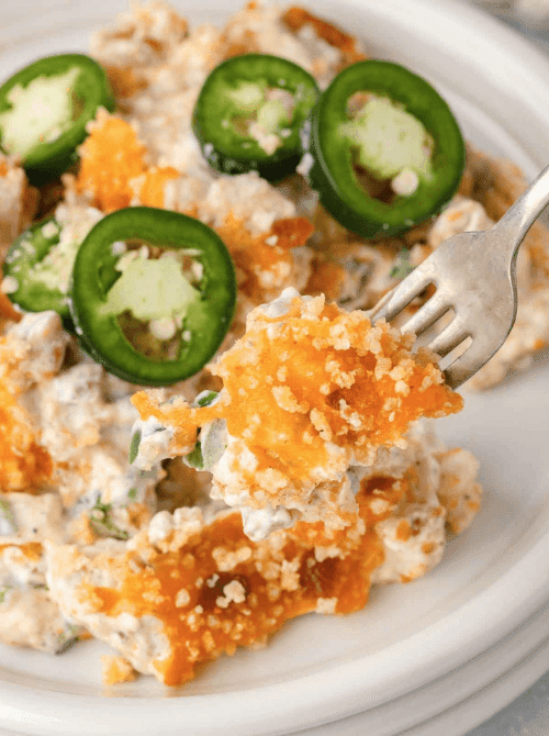 Close-up of a creamy jalapeño popper chicken casserole with crispy golden topping and fresh jalapeño slices, shown as part of easy weeknight dinners and comforting chicken casseroles.