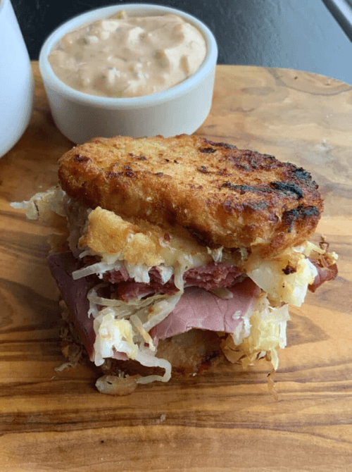 Corned beef Reuben casserole sandwich layered with sauerkraut and cheese, served as hearty Irish party food for a St. Patrick’s Day celebration.
