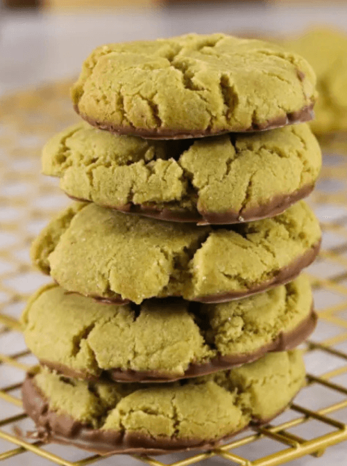 Stack of soft pistachio cookies dipped in chocolate on a cooling rack, featured in festive St. Patrick’s Day Dessert Ideas for a cozy party spread. 🍀