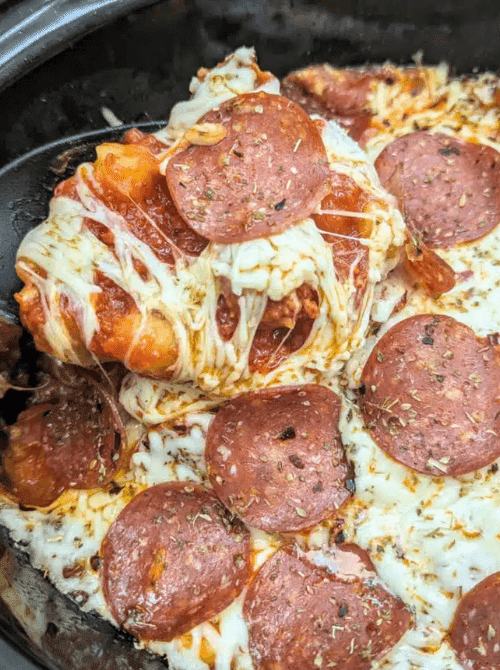Cheesy pepperoni pizza casserole served from a skillet, featuring melted mozzarella and sliced pepperoni, perfect for super easy casseroles and comforting family dinner ideas.