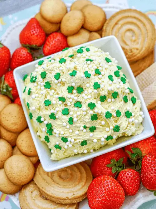 Square shamrock sprinkle cake dip surrounded by vanilla wafers, shortbread cookies, and fresh strawberries, styled for crowd-friendly St. Patrick’s Day Dessert Ideas. 🍀