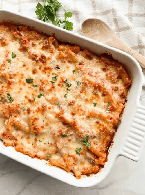 Cheesy baked chicken casserole with a golden crust and herbs in a white dish, a comforting comfort casseroles recipe for easy comfort food and recipes for busy nights.
