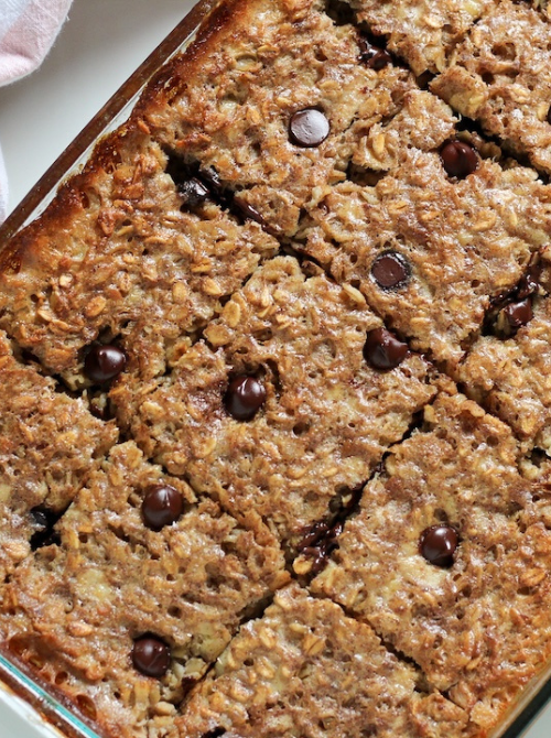 Banana chocolate chip baked oatmeal cut into squares in a glass baking dish, a wholesome sweet option often included in make-ahead Easter brunch casseroles.