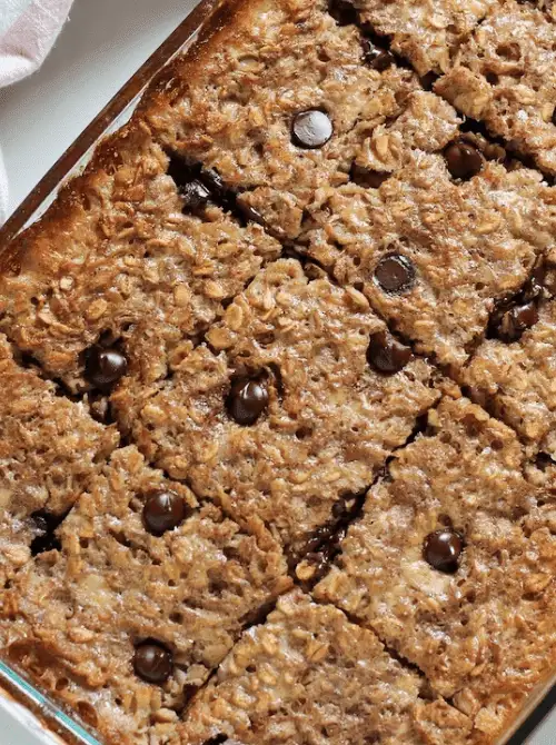 Banana chocolate chip baked oatmeal cut into squares in a glass baking dish, a wholesome sweet option often included in make-ahead Easter brunch casseroles.