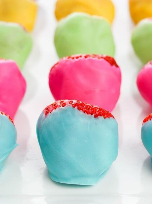 Pastel no-bake Easter-themed desserts for a bake sale, featuring strawberries dipped in colorful candy coating in shades of blue, pink, green, and yellow for a festive Easter treat.