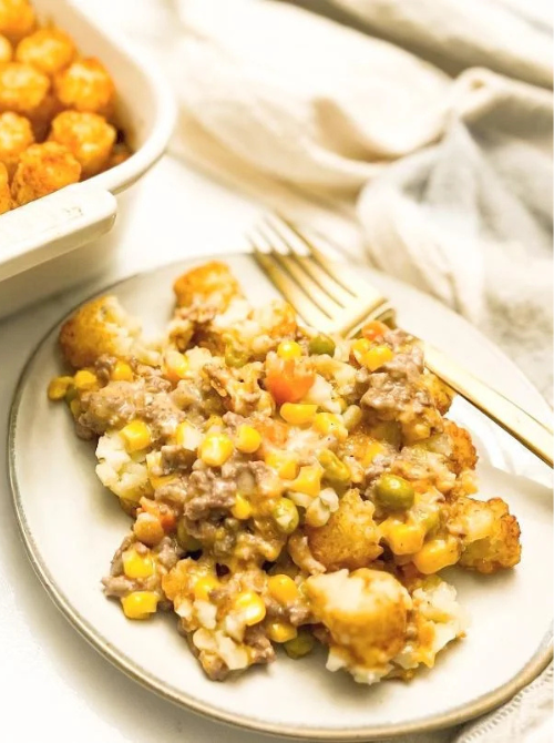 Savory tater tot casserole with ground beef, mixed vegetables, and creamy sauce served on a plate, a comforting comfort casseroles meal for easy comfort food and recipes for busy nights.