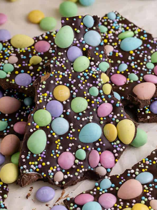 Tree-shaped chocolate bark covered with pastel candy eggs and colorful sprinkles, a festive no-bake Easter-themed dessert for a bake sale.