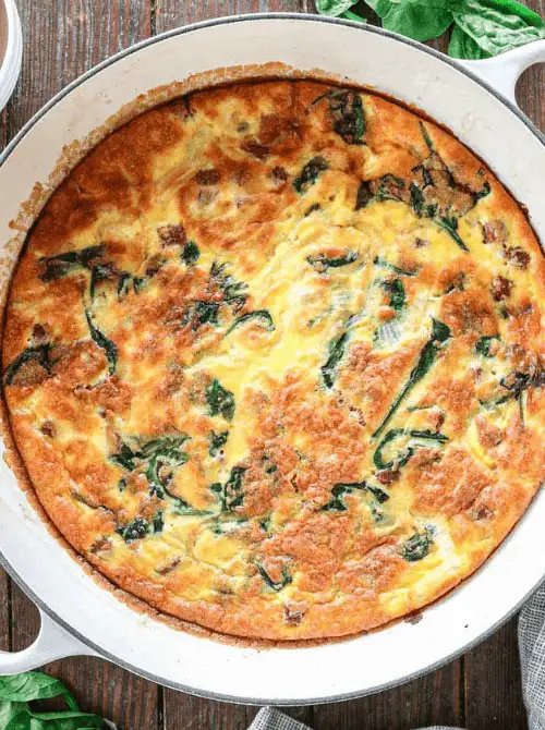 Golden spinach and egg breakfast bake in a white skillet, a savory vegetable-packed option for make-ahead Easter brunch casseroles perfect for a spring holiday meal.