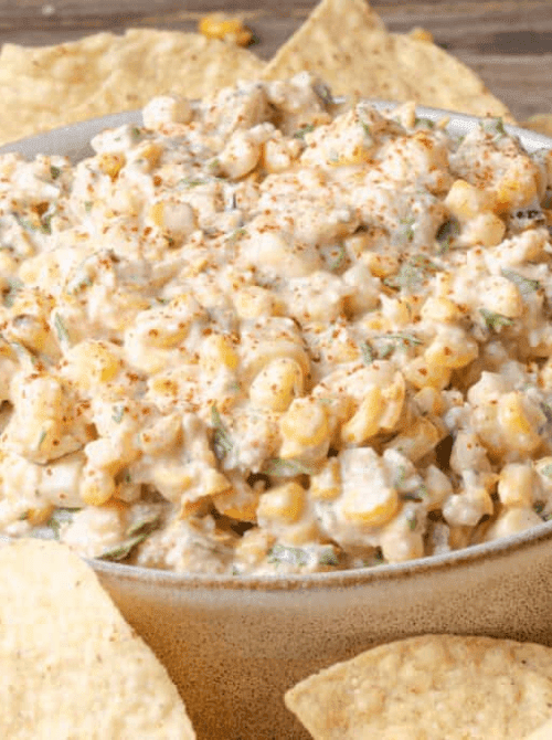 Creamy Mexican street corn dip with cotija cheese, green chiles, and smoked paprika served with tortilla chips — an easy Cinco de Mayo party food recipe for a crowd that doubles as a dip and a side dish.