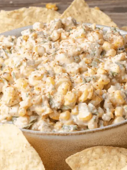 Creamy Mexican street corn dip with cotija cheese, green chiles, and smoked paprika served with tortilla chips — an easy Cinco de Mayo party food recipe for a crowd that doubles as a dip and a side dish.