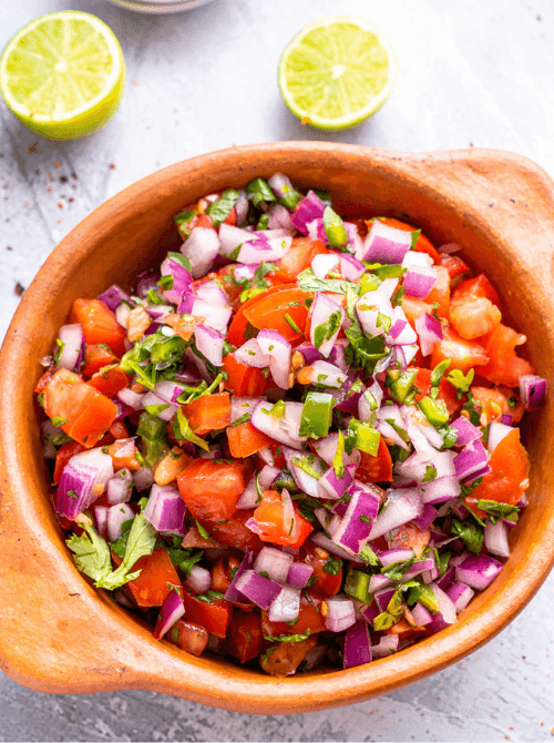 Fresh homemade pico de gallo in a wooden bowl with diced tomatoes, red onion, jalapeño, and cilantro — an easy Cinco de Mayo party food recipe for a crowd that takes just 10 minutes to make.