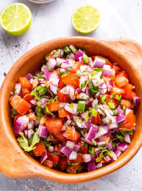 Fresh homemade pico de gallo in a wooden bowl with diced tomatoes, red onion, jalapeño, and cilantro — an easy Cinco de Mayo party food recipe for a crowd that takes just 10 minutes to make.