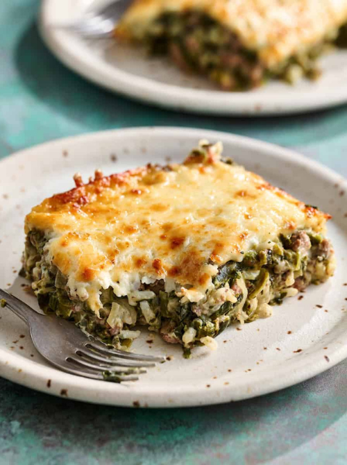 Creamy spinach and cheese casserole with a golden baked top served on a plate, a satisfying comfort casseroles option for easy comfort food and recipes for busy nights.