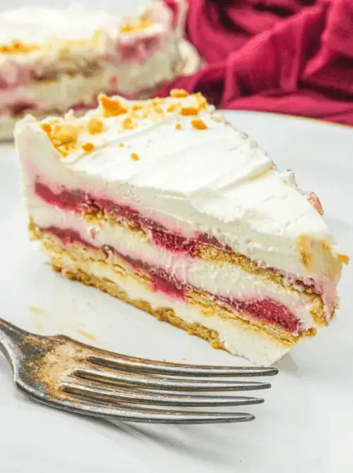 Slice of strawberry gingersnap icebox cake showing distinct layers of cream cheese filling, strawberry jam, and gingersnap cookies on a white plate — an easy no-bake homemade strawberry cake recipe
